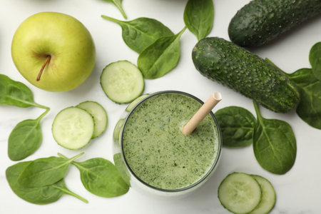 Tasty spinach smoothie and ingredients on white table, flat layの写真素材