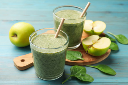 Tasty spinach smoothie and ingredients on light blue wooden table, closeupの写真素材