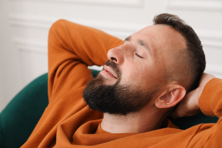 Harmony. Man relaxing in comfortable armchair at home, closeup