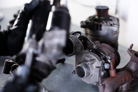 Auto parts. Professional mechanic with starter motor indoors, focus on turbocharger