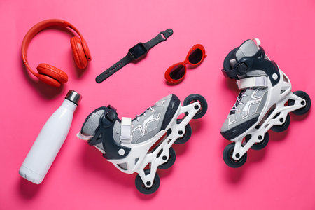 Flat lay composition with roller skates on pink background