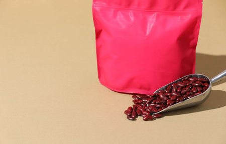 Zipper stand-up pouch and dry kidney beans on beige background, closeup. Mockup for designの写真素材