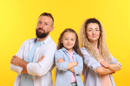 Portrait of family with crossed arms on yellow backgroundの写真素材