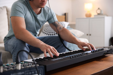 Man working with MIDI keyboard at table indoors, closeupの写真素材