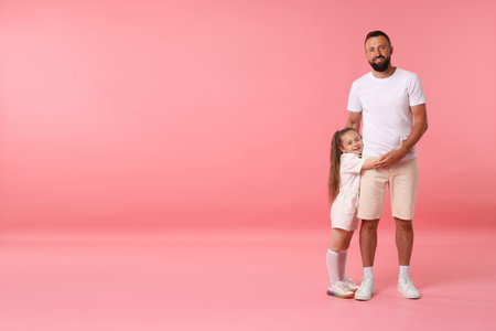 Family. Happy father and his daughter on pink background. Space for textの写真素材