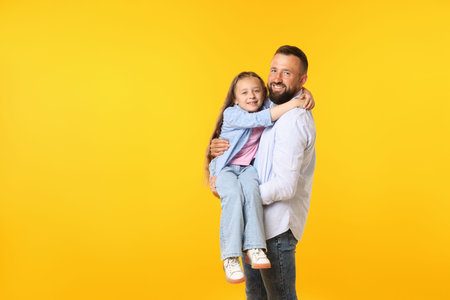 Family. Happy father and his daughter on yellow background. Space for textの写真素材