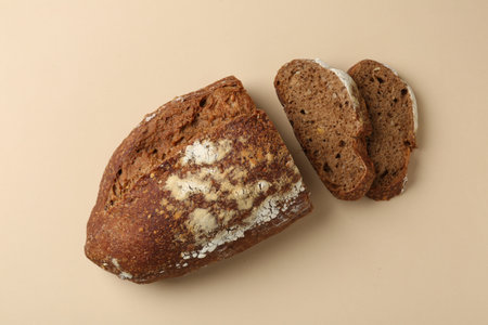 Pieces of fresh rye bread on beige background, flat lay
