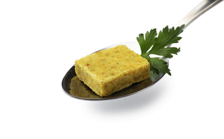 Aromatic bouillon cube, parsley and spoon isolated on whiteの写真素材