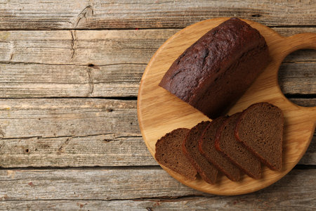 Pieces of fresh rye bread on wooden table, top view. Space for text