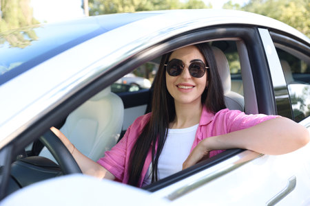 Woman behind steering wheel of modern car, view from outsideの写真素材