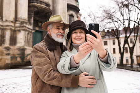 Happy senior couple taking selfie on winter dayの写真素材