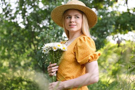 Beautiful woman with bouquet of wildflowers in forestの写真素材