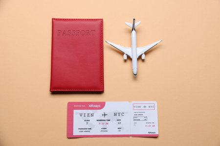 Airplane model, passport and flight ticket on beige background, flat lay