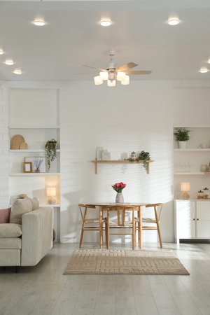 Stylish dining table with chairs and comfortable sofa in room. Interior design