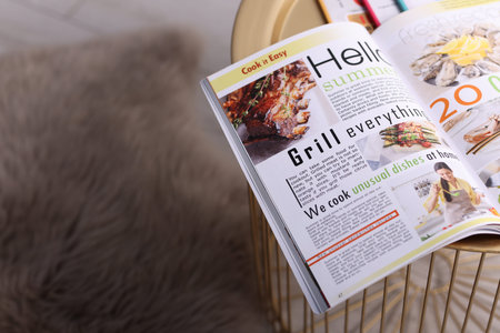 Open trendy magazine on table indoors, above view. Space for text