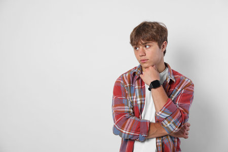 Cute teenage boy on light grey background. Space for textの写真素材