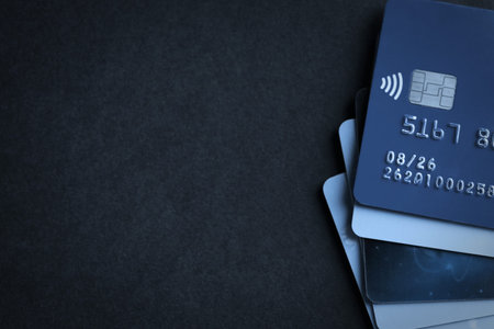 Many different credit cards on black table, top view