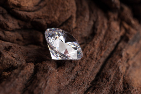 One beautiful shiny diamond on wood, closeup