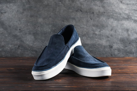 Pair of dark blue shoes on wooden surface