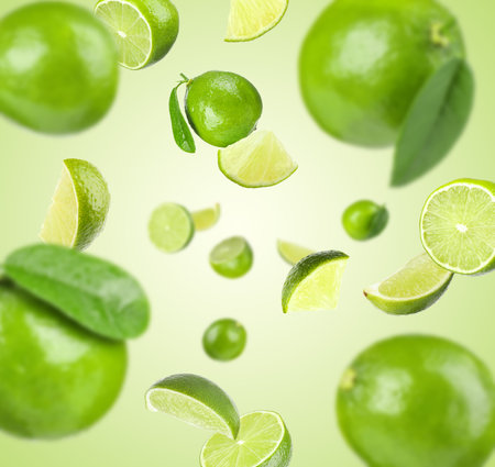 Fresh ripe limes flying on light green gradient background