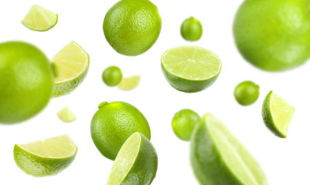 Fresh ripe limes flying on white background