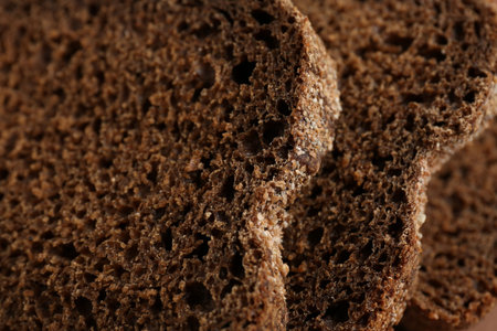 Pieces of fresh rye bread as background, closeup