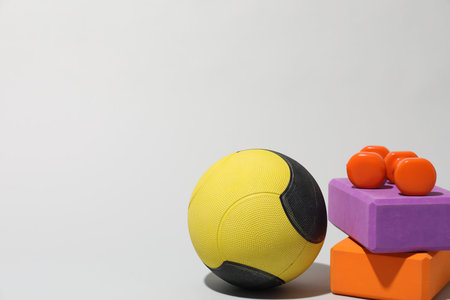 Medicine ball, dumbbells and foam blocks on light gray background, space for textの写真素材