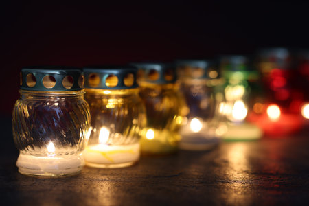Many grave candles on dark background, closeup