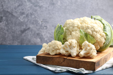 Raw cauliflower on blue wooden table. Space for textの写真素材