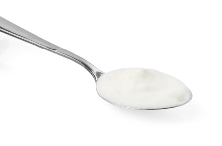 Tasty yoghurt in spoon isolated on whiteの写真素材