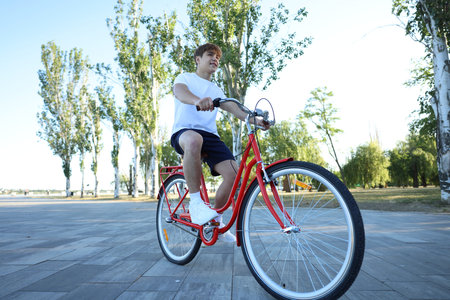 Teenage boy riding bicycle on city street