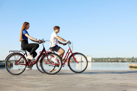Teenage girl and boy riding bicycles outdoors