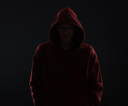 Anonymity. Man hiding his face in darkness