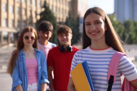 Group of teenagers walking together on city street, selective focus