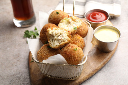 Delicious fried croquette balls and sauces on gray textured table, closeupの写真素材