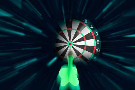 Dart flying into center of target against black background, motion blur effectの写真素材