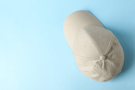 Beige baseball hat on light blue background, top view. Space for textの写真素材