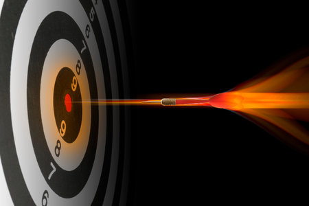 Dart flying into center of target against black background, motion blur effect