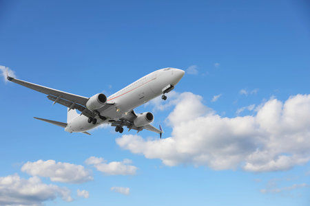 Airplane flying in beautiful blue sky with clouds