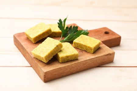 Aromatic bouillon cubes and parsley on wooden table, closeupの写真素材