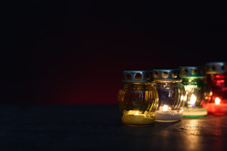 Many grave candles on dark background, closeup. Space for textの写真素材