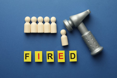 Dismissal. Word Fired, hammer and human figures on blue background, flat layの写真素材