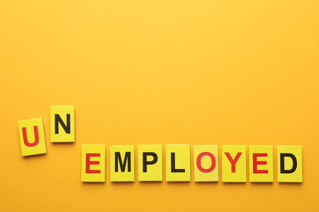 Word Unemployed on yellow background, top view. Space for textの写真素材