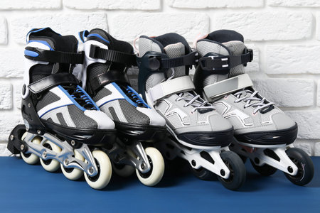 Roller skates on blue table near white brick wall