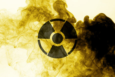 Radioactive sign and yellow toxic smoke against white background