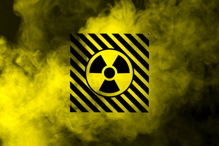 Radioactive sign and yellow toxic smoke against black background