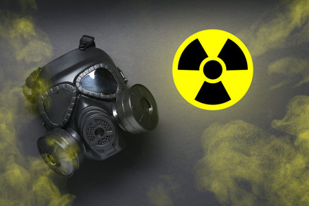 Radiation threat. Gas mask, radioactive sign and smoke on gray background, top view
