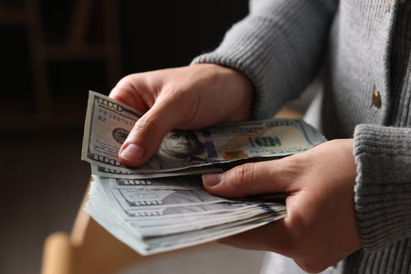 Woman counting her money indoors, closeup view