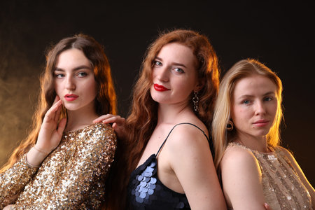 Beautiful women with different hair colors on dark background with smokeの写真素材