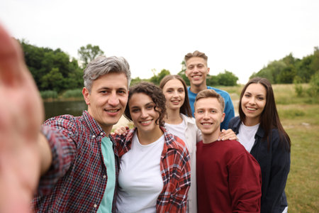 Team building. Group of happy people taking selfie outdoors